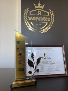 Статуетката и грамотата „Застрахователен брокер на годината 2025“ пред логото на Winners Group